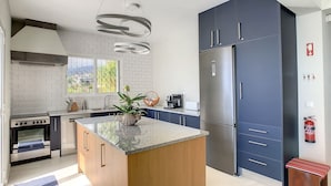 Eine moderne Küche mit Kochinsel, Backofen und Kühlschrank.