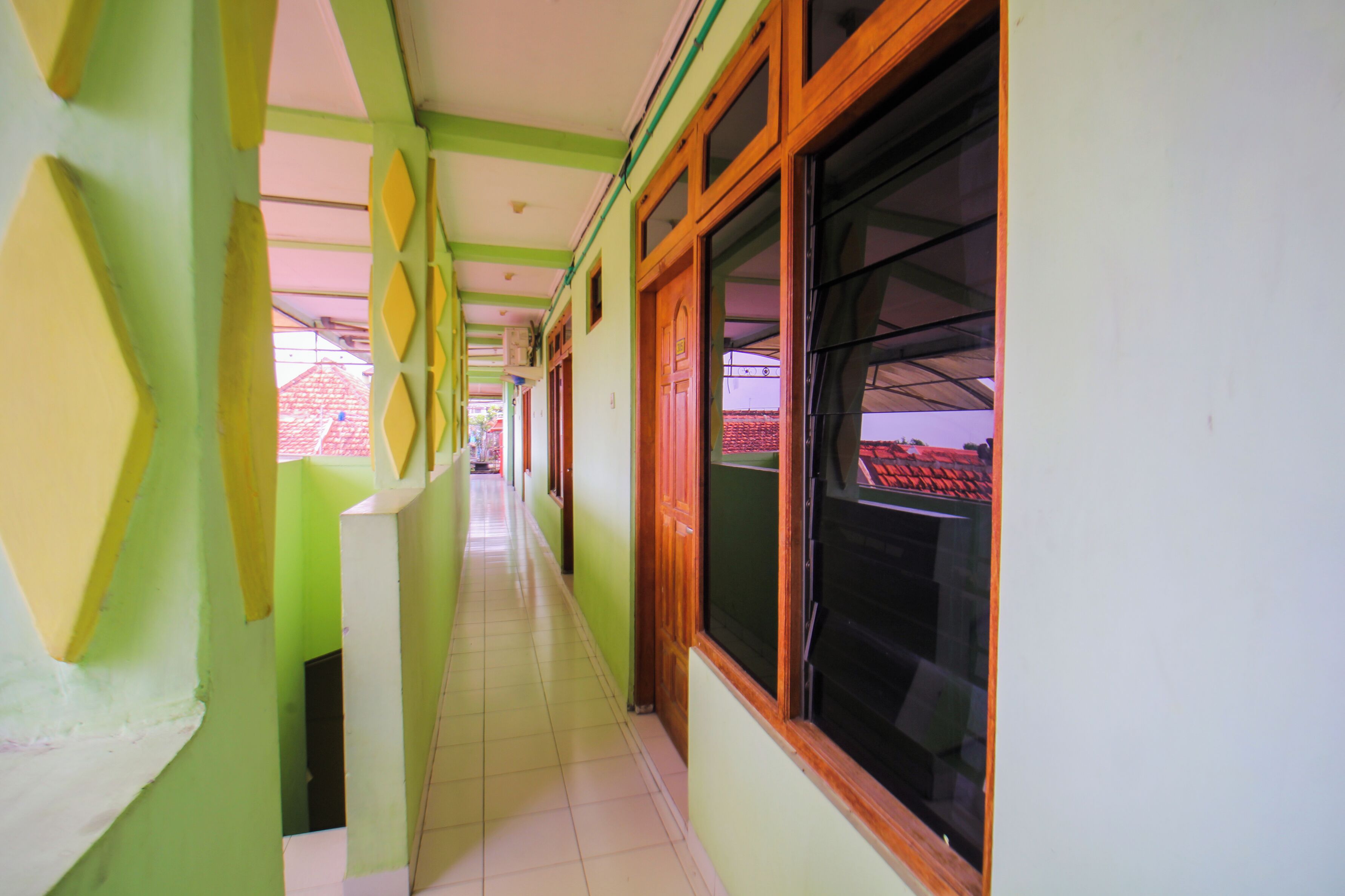 A corridor with green walls and large windows.