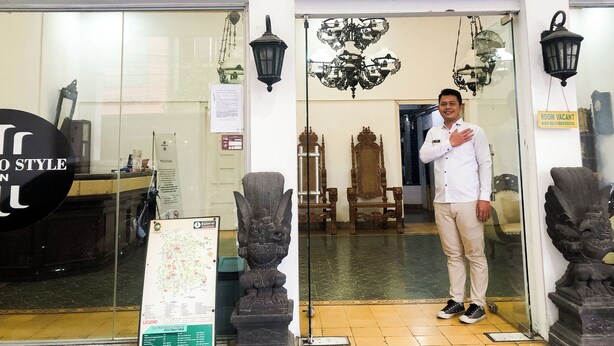 A hotel entrance with a sign reading "PRAYOGO STYLE INN" and a man standing in the doorway. - Prayogo Style Inn Prawirotaman (Yogyakarta)