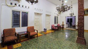 A hotel lobby with patterned flooring, seating areas, and decorative lighting fixtures. - Prayogo Style Inn Prawirotaman (Yogyakarta)