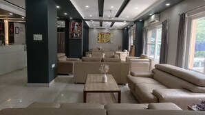 Un moderno vestíbulo de hotel con una recepción, zona de estar, obras de arte y grandes ventanales.
