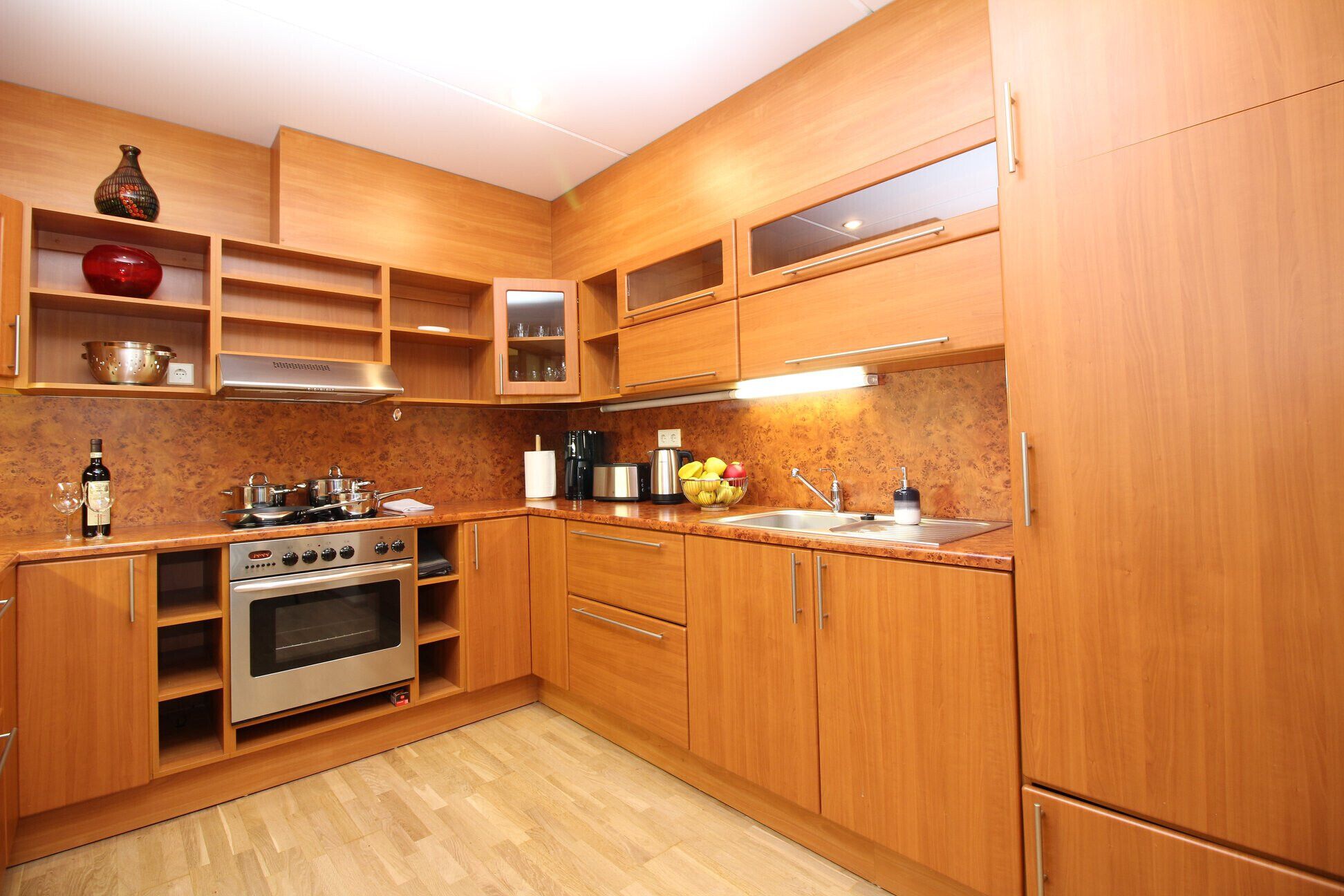 A kitchen with wooden cabinets, a stove, and a sink.