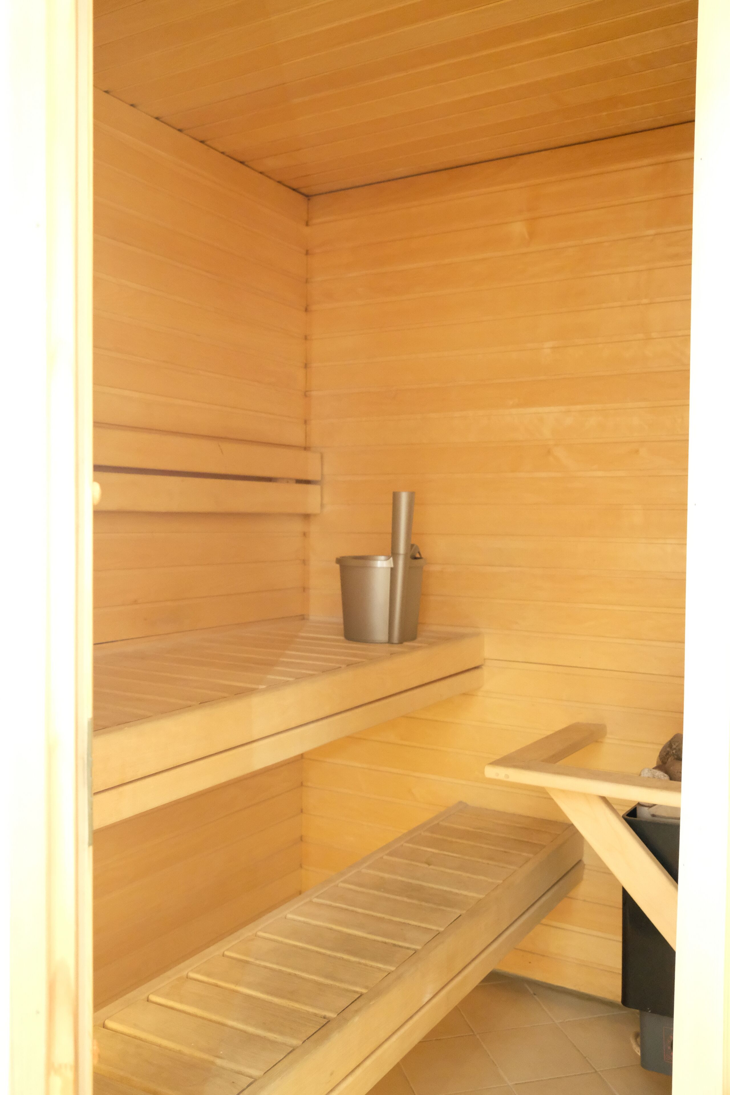 A sauna room with wooden walls and benches.