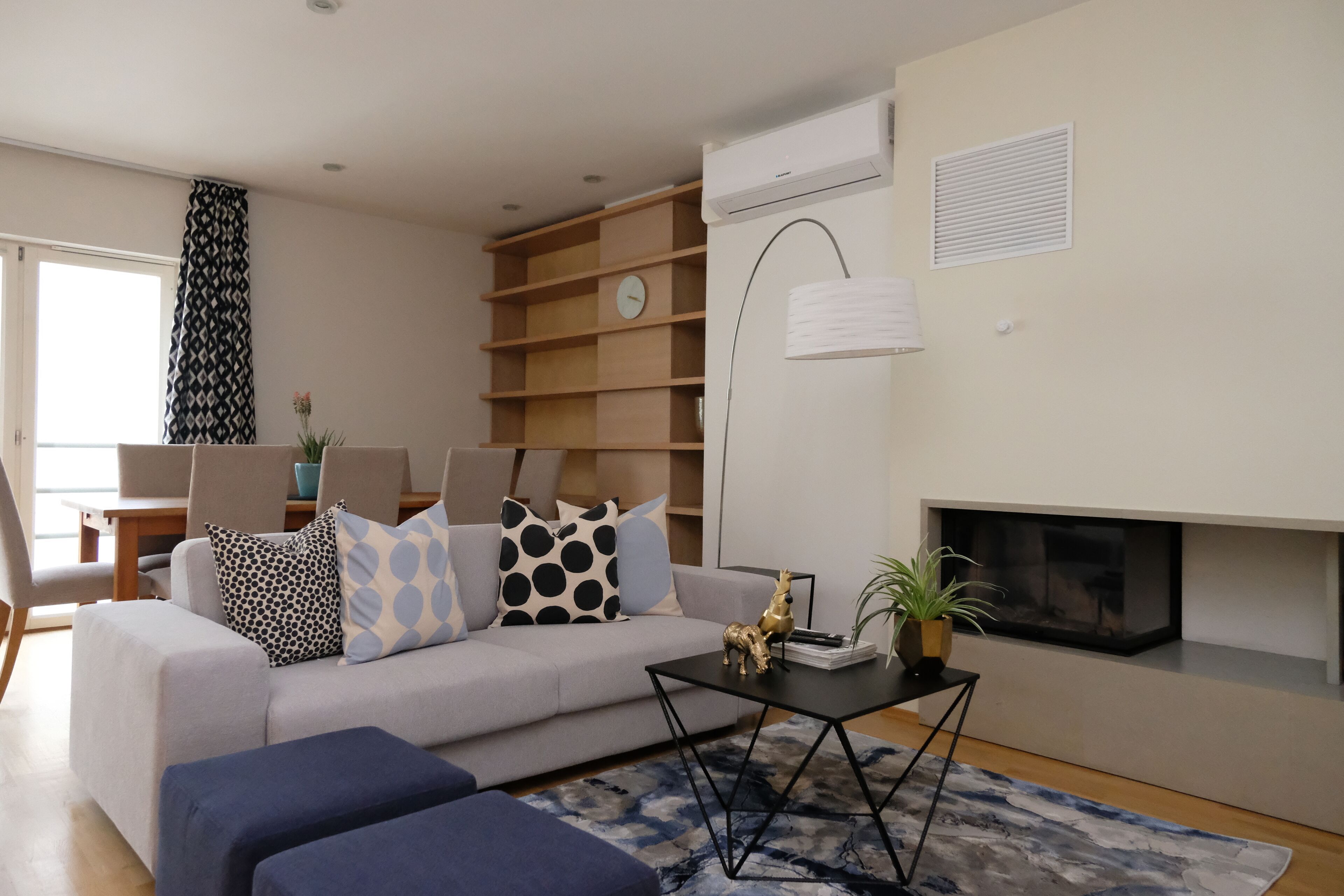 A modern living room with a sofa, coffee table, and a fireplace.