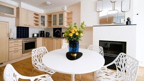A modern kitchen with white cabinetry, a round dining table, and chairs. - Tallinn City Apartments Roosikrantsi (Tallinn)
