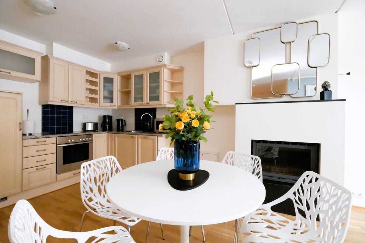 Una cocina moderna con armarios blancos, una mesa redonda y sillas.