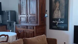 A living room with a brown sofa, a wooden cabinet, and a poster on the wall. - lac D'annecy Dans Maison de Charme (Doussard)