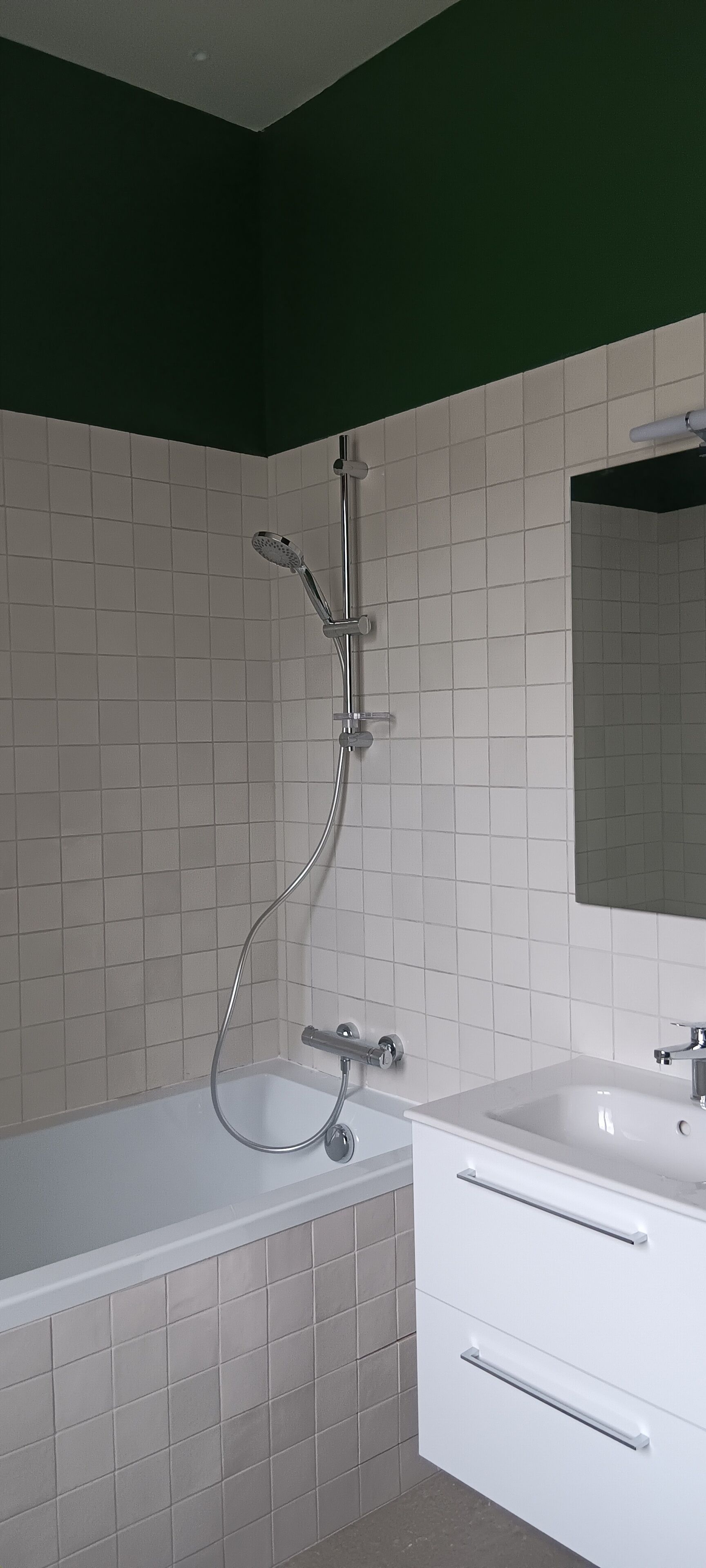 A bathroom with a bathtub, a shower, and a sink with a mirror.