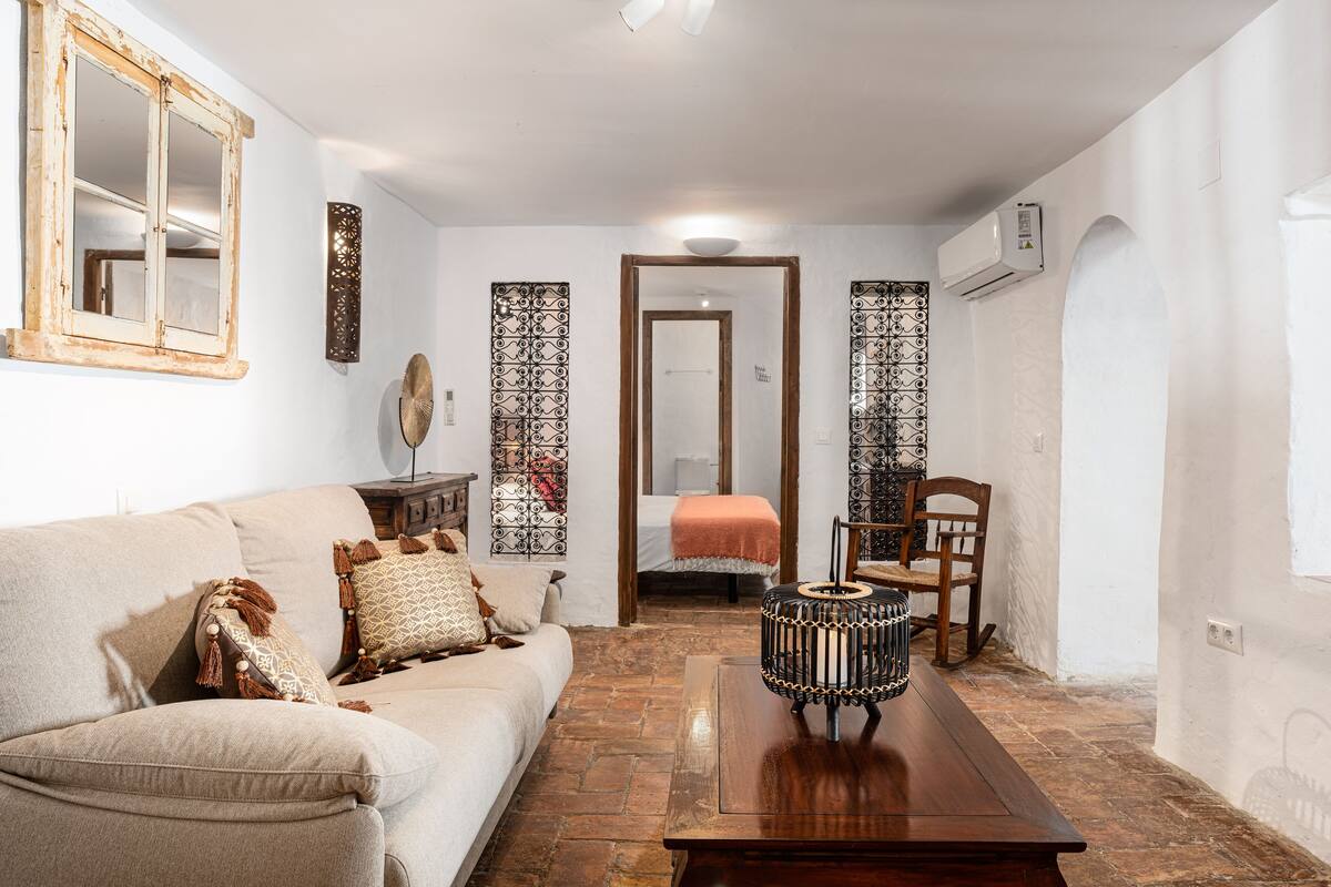 Un salon avec un canapé, une table basse en bois et un mur orné d’un motif.