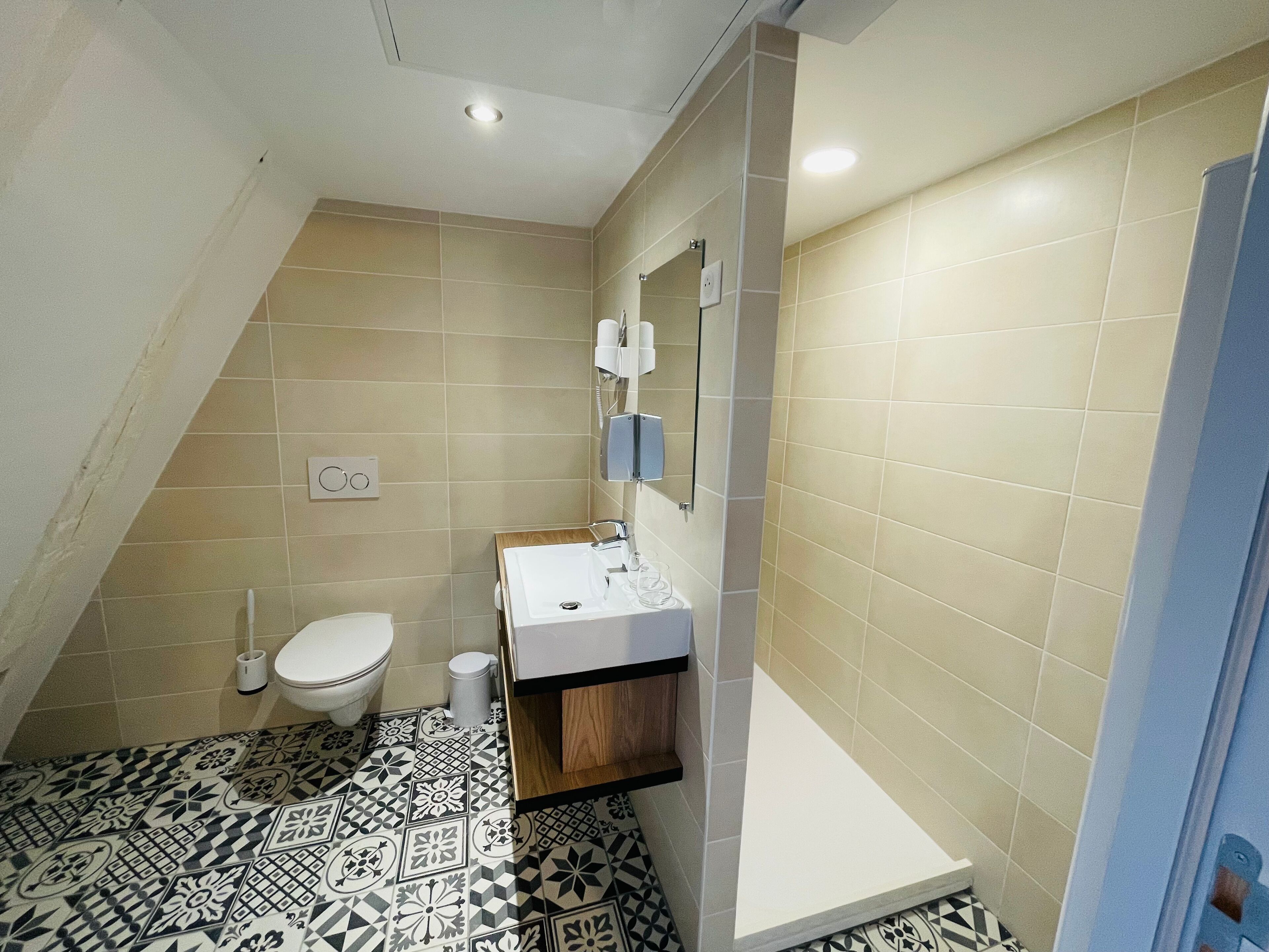 Une salle de bain comprenant des toilettes, un lavabo et un espace douche.
