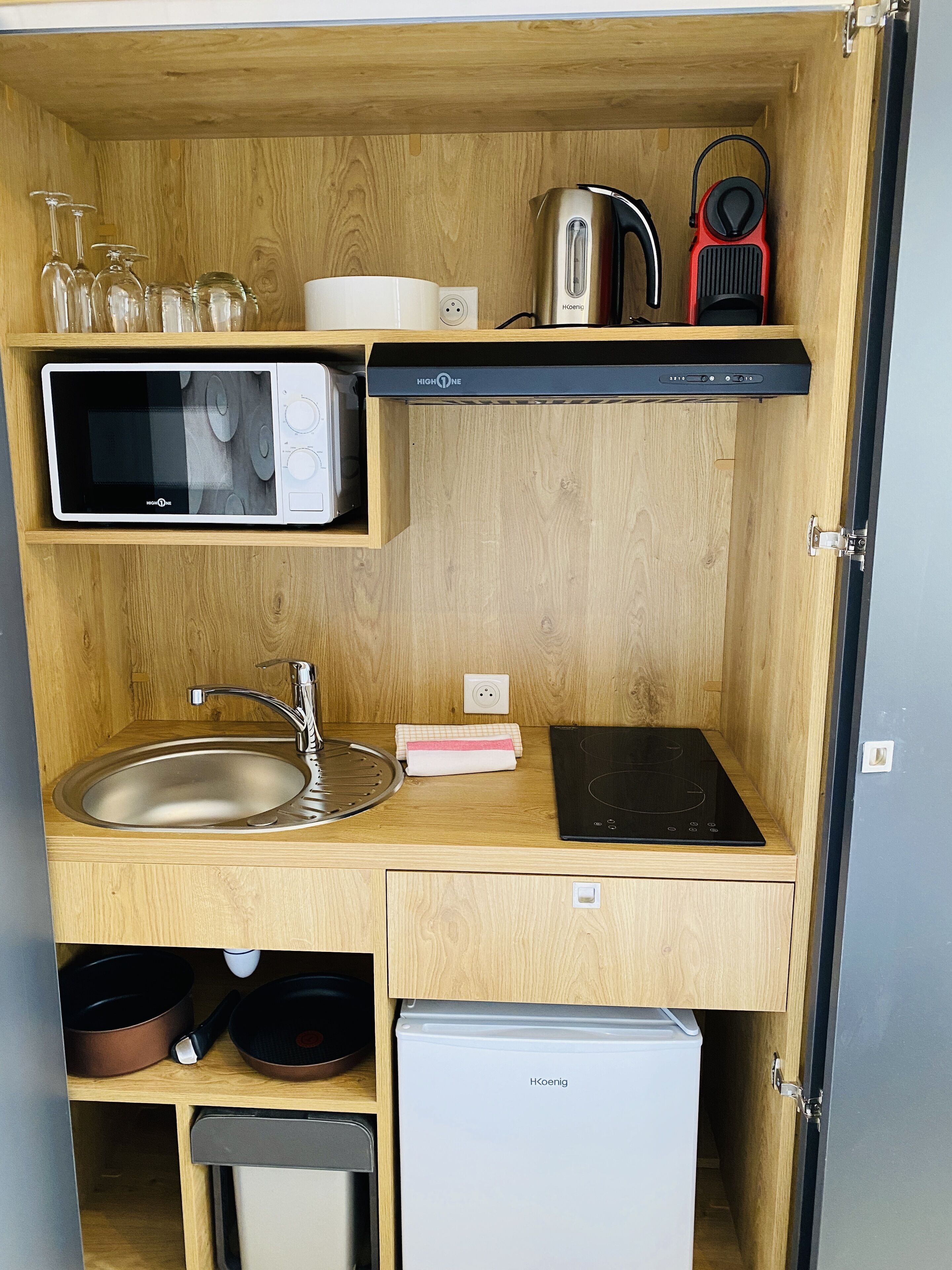 Une petite cuisine équipée d’un four à micro-ondes, d’une bouilloire, d’un grille-pain, d’un évier et d’un petit réfrigérateur.