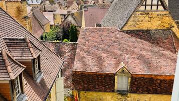 A traditional European town with historic buildings, narrow streets, and a visible courtyard with a banana plant.