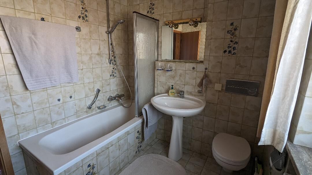 A bathroom with a bathtub, sink, and toilet.