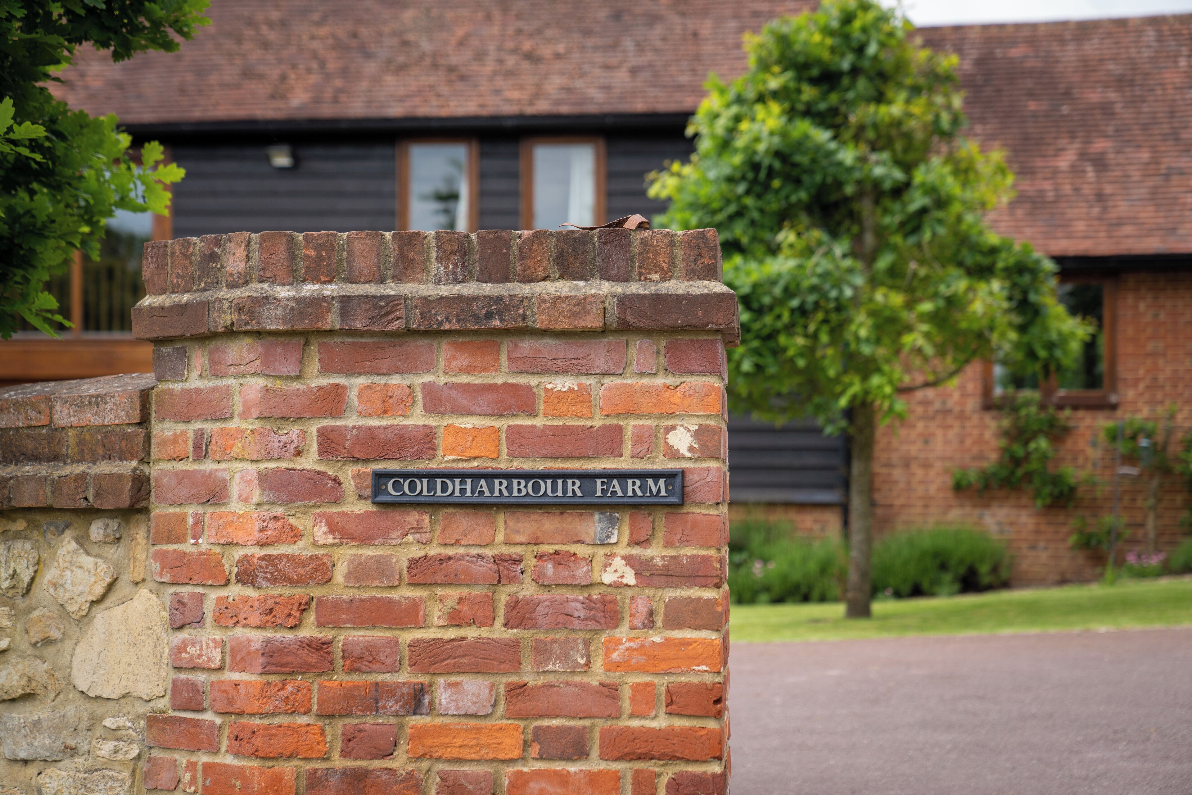 A brick wall with a sign reading "Cold Harbour Farm."