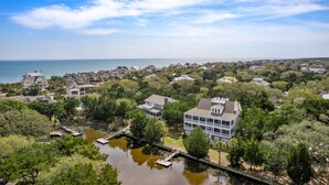 Una zona residencial costera con casas, un muelle y una masa de agua.