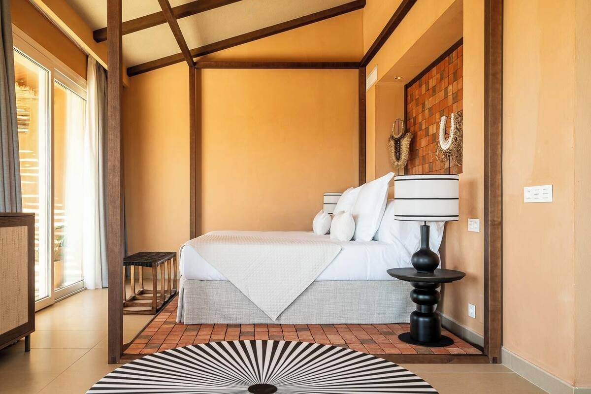 Ein Schlafzimmer mit einem Bett, einem Nachttisch, einer Lampe und einer Wanddekoration.