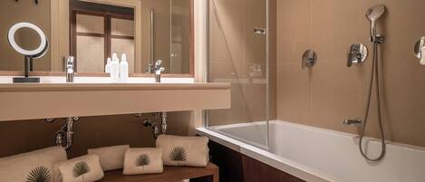 A modern bathroom with a large bathtub, a separate shower area, and a vanity with a mirror and sink.