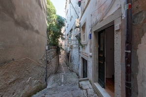 Stroll through a historic cobblestone alleyway leading to a charming entrance.