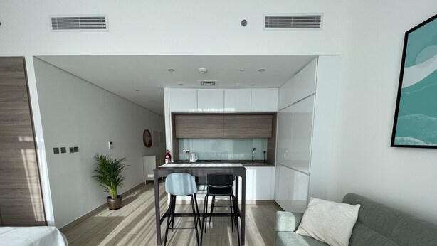 A modern apartment with a kitchen, dining area, and living room.