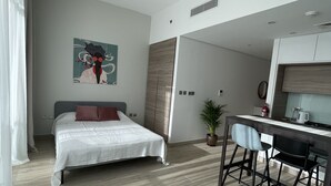 A modern bedroom with a bed, a desk, and a dining area.