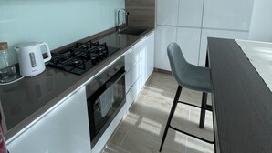 A modern kitchen with white cabinets, a gas stove, and a dining area with a table and chairs.