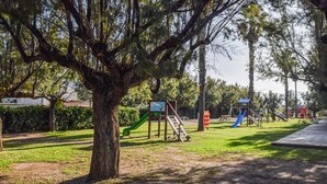 A park with playground equipment, including slides and climbing structures, surrounded by trees and grass. - 2 bedroom beautiful home in Torrenova (Torrenova)
