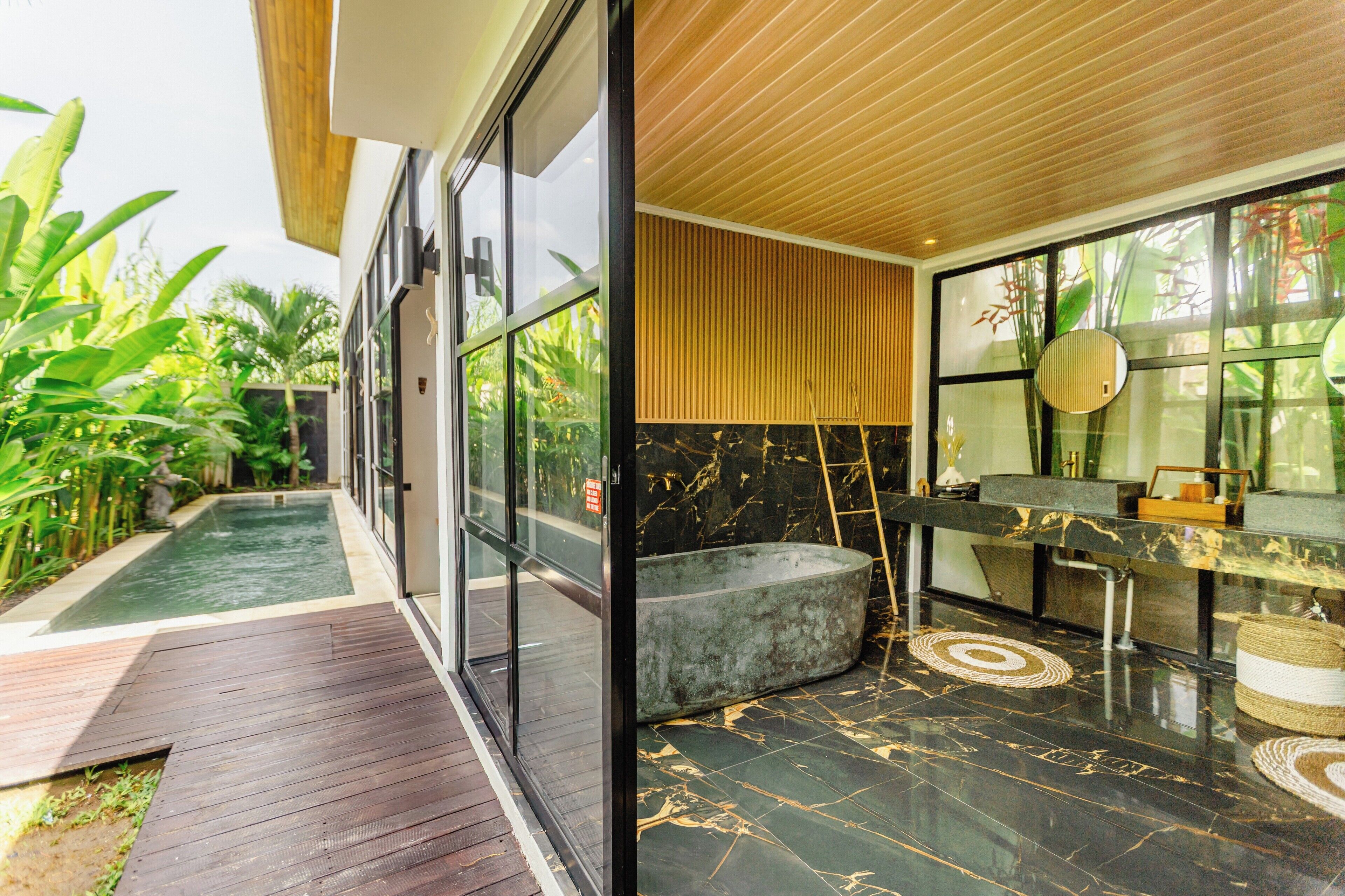 A modern bathroom with a marble floor, a large window, and a wooden ceiling.