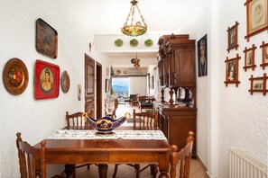 Enjoy meals in this dining area with a table for four, surrounded by classic chairs and decorative accents.