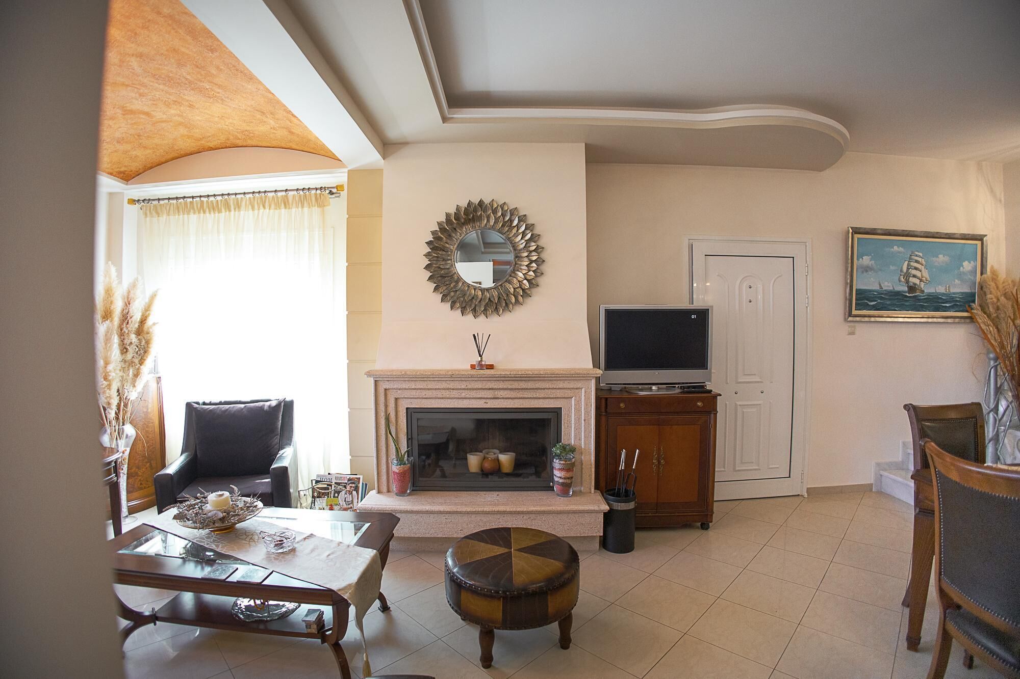A living room with a fireplace, a television, and a dining area with a table and chairs.