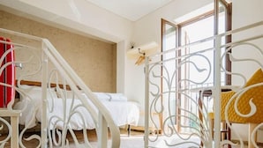 A staircase with white metal railings leading to a bedroom with a bed and a window. - La Casa Delle Api  (Offida)
