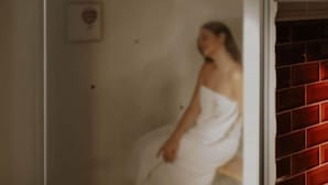 A person in a white towel sitting in a room with a red brick wall. - La Casa Delle Api  (Offida)