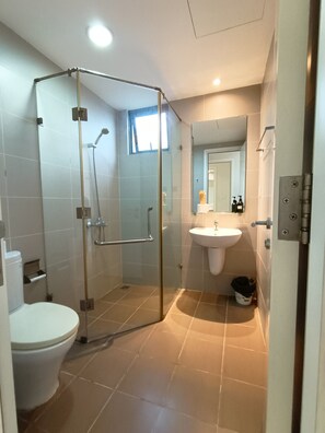 A modern bathroom with a glass-enclosed shower, a white sink, and a toilet. - Masteri Thao Dien Apartment  Quan 2 (Ho Chi Minh City)