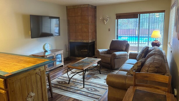 A living room with a fireplace, a sofa, a coffee table, and a television.