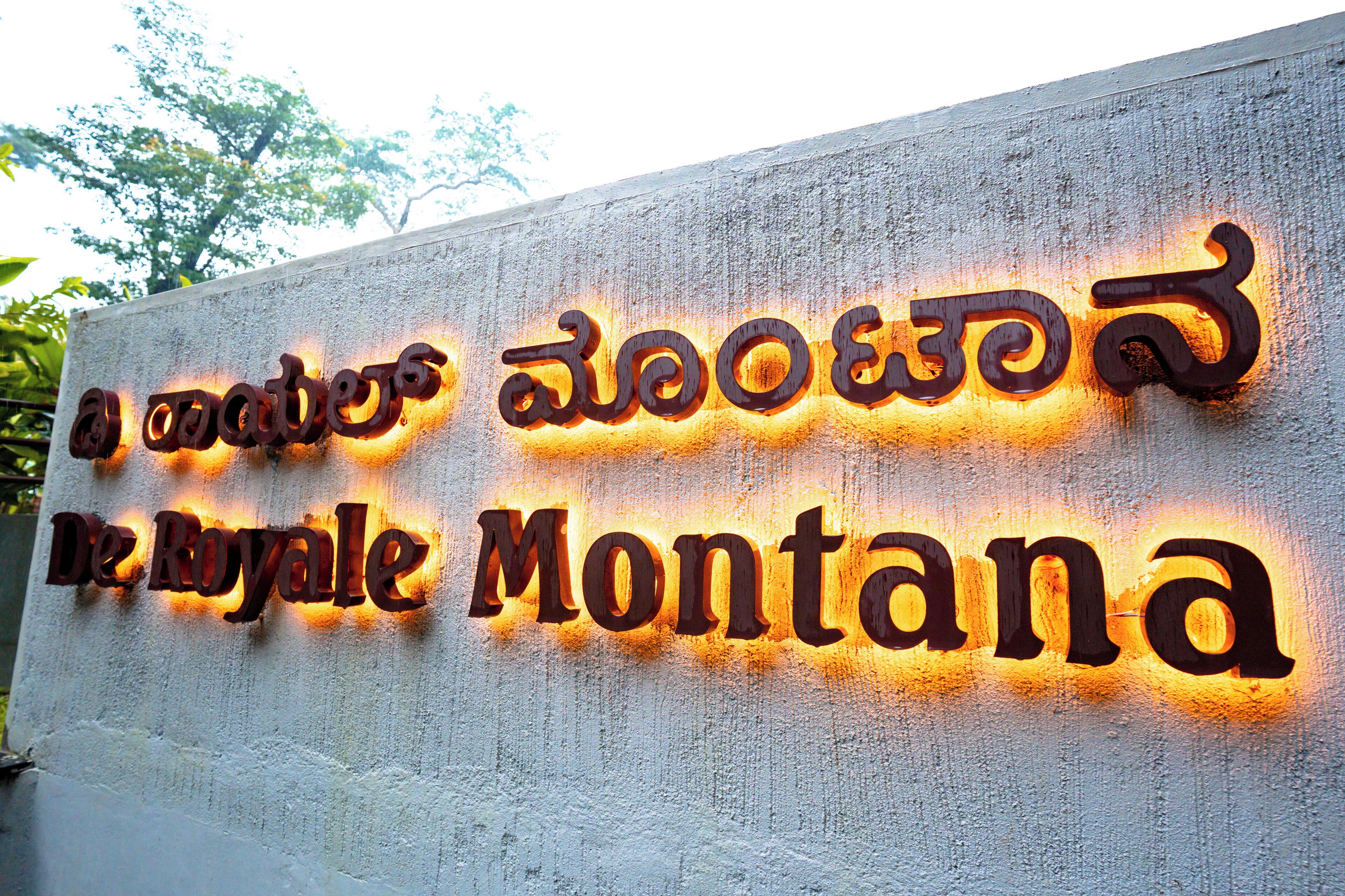 A sign with the name "De Royale Montana" in both English and another script.