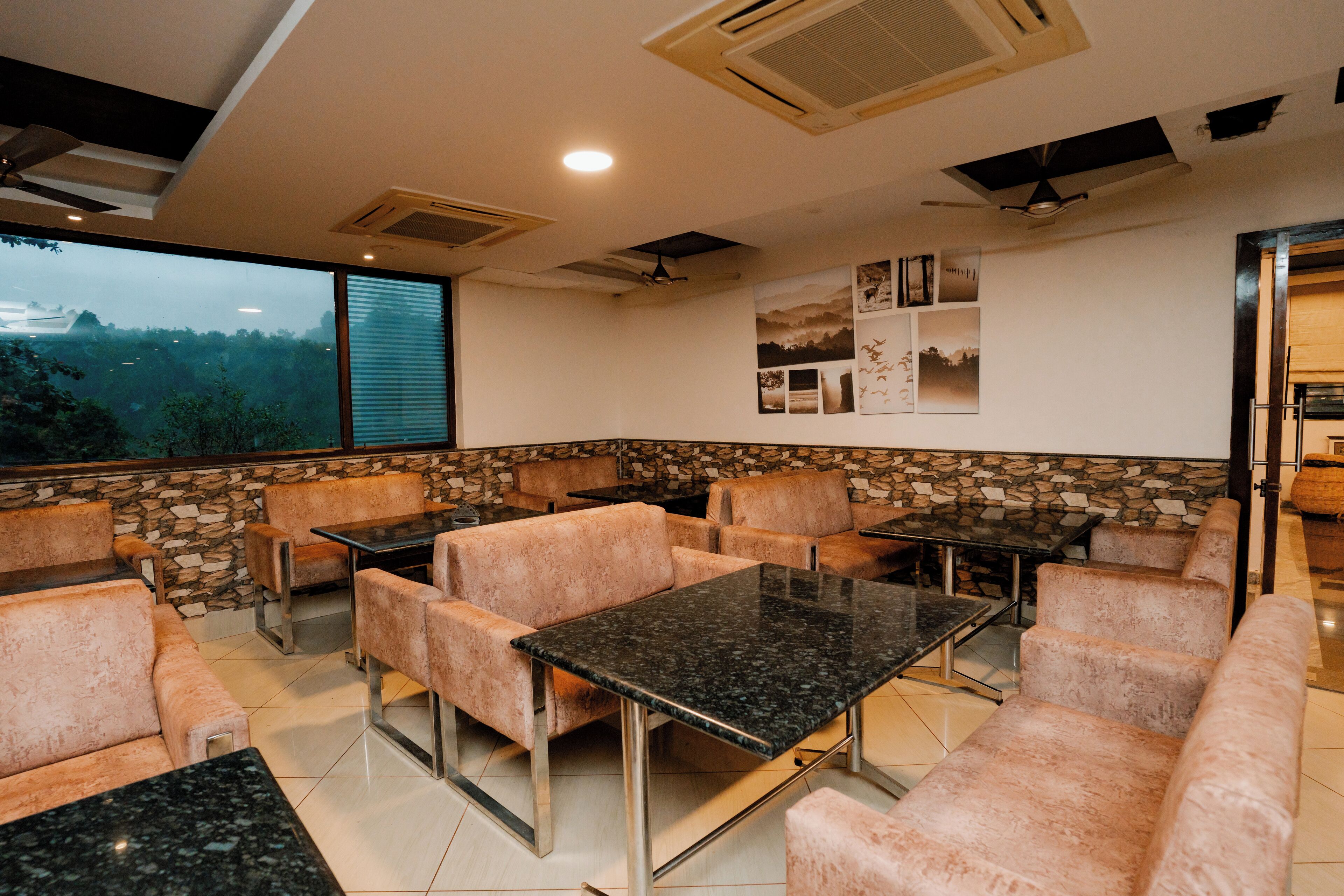 A restaurant with stone walls, cushioned seating, and a view of the outdoors.