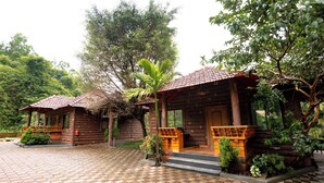A wooden cabin with a tiled patio and a small garden area.