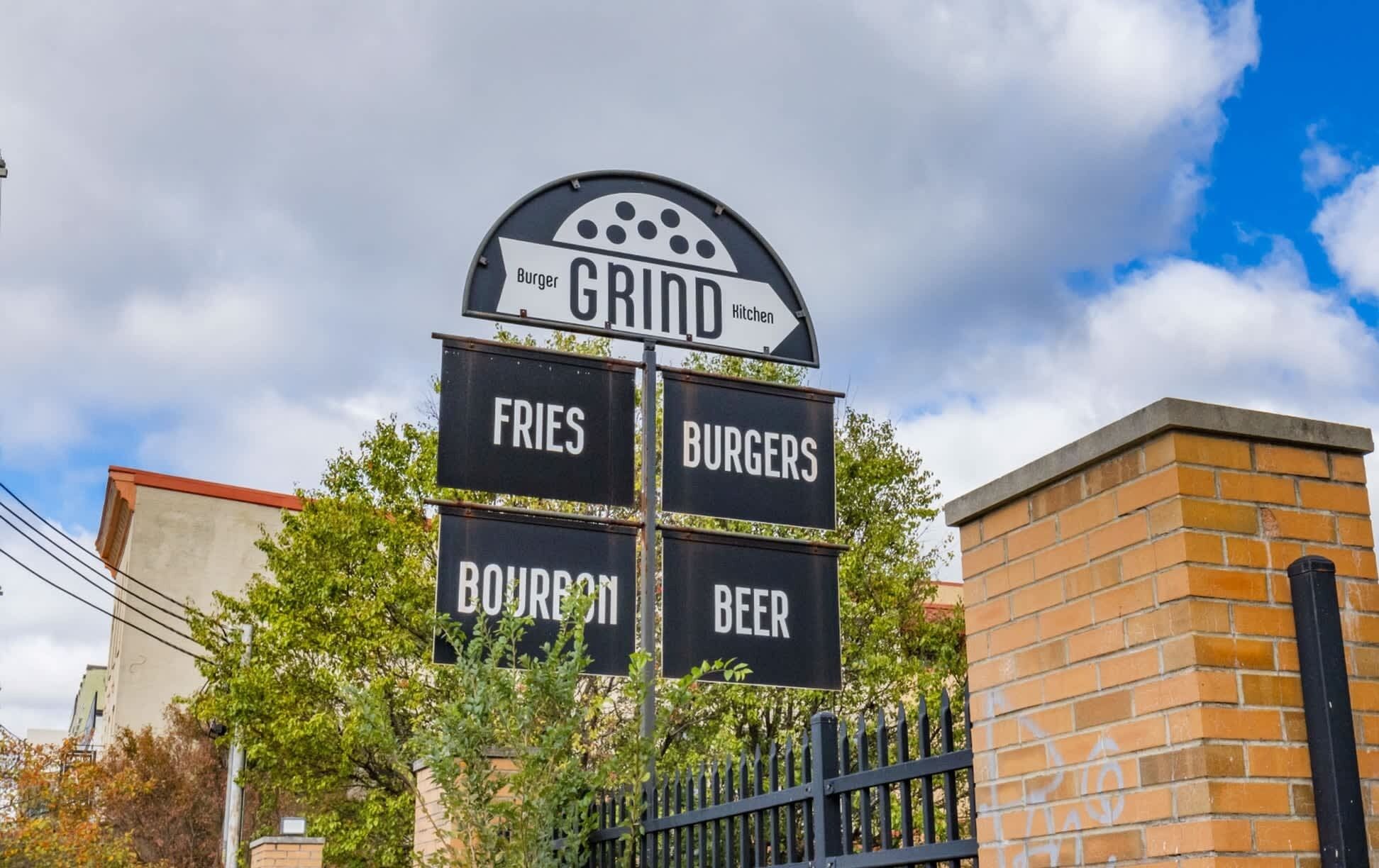 A sign for a restaurant named 'Gridd' offering burgers, fries, boeuf bourguignon, and beer.