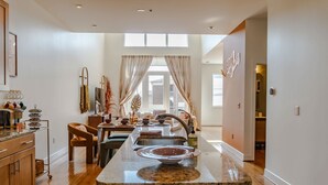 Une cuisine moderne dotée d’un îlot central, de meubles en bois et d’un coin repas avec une chaise et une table.