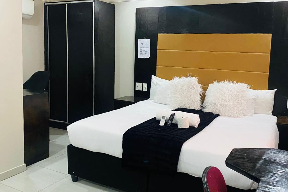 Una habitación de hotel moderna con una cama grande, un escritorio y un armario.