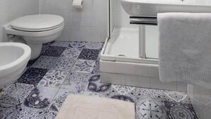 Un baño con ducha, inodoro y lavamanos.