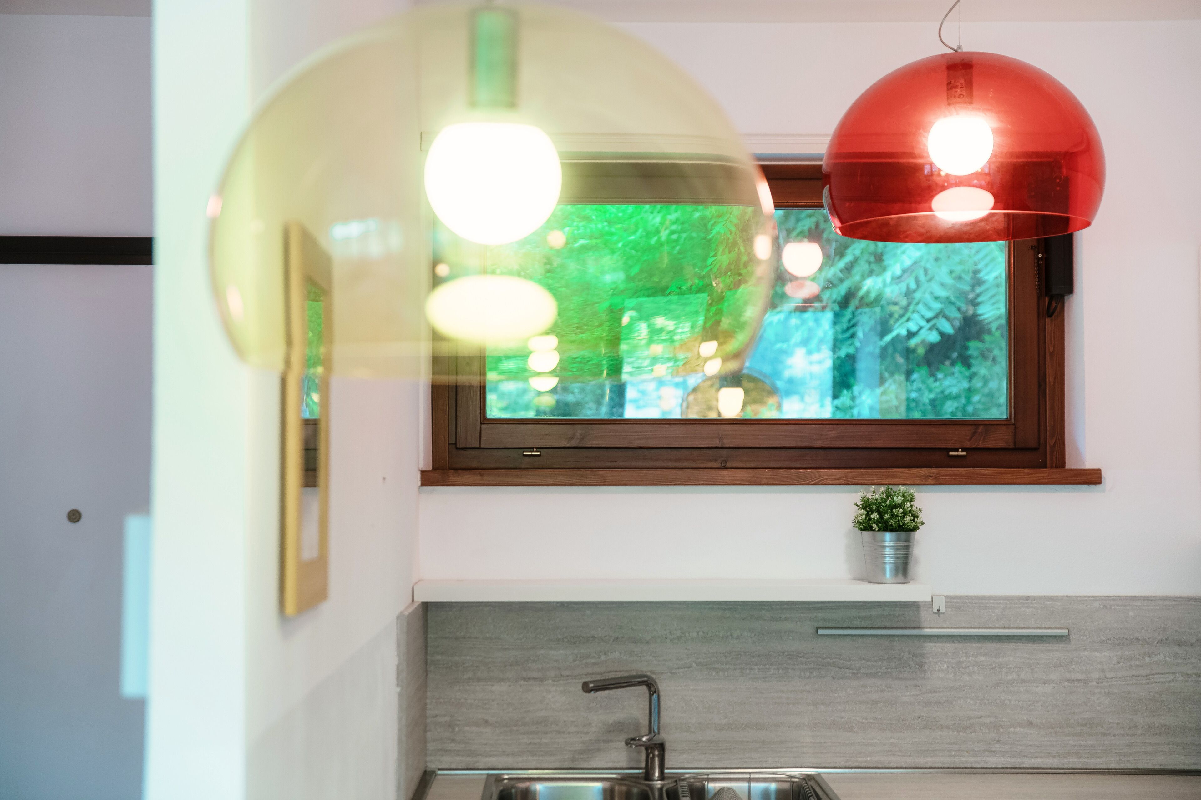 Une cuisine moderne avec une fenêtre, un évier et une plante en pot.