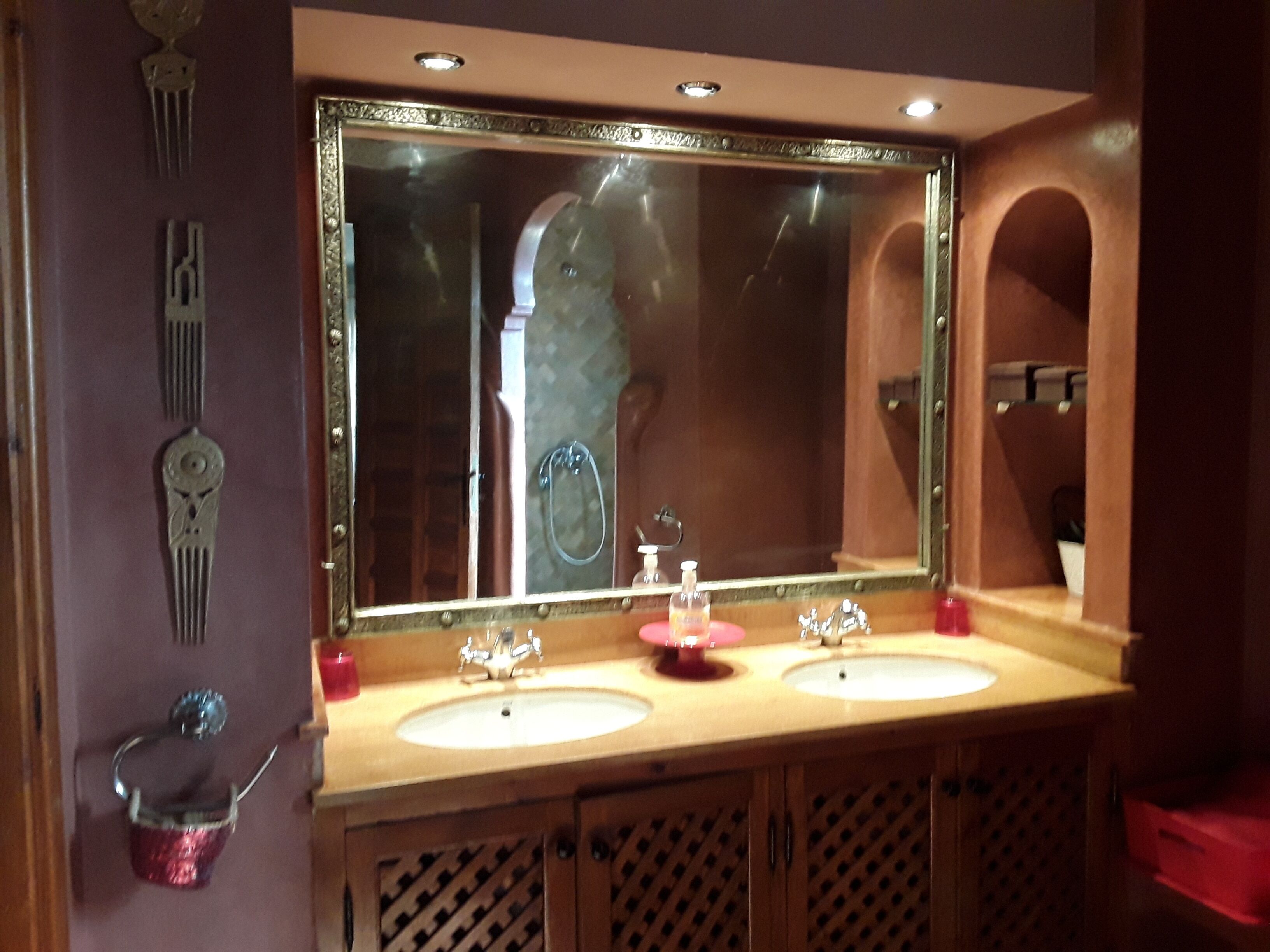 A bathroom with two sinks, a large mirror, and a vanity cabinet.