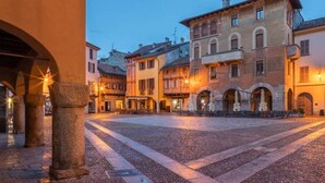 A historic square with cobblestone pavement, classical architecture, and warm lighting. - Nest In Como - A Nest In The City Of Como for 6 (Como)