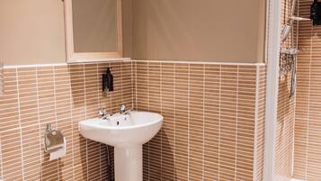 Ein Badezimmer mit Waschbecken, Toilette und Dusche.
