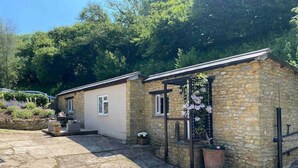 A stone cottage with a small garden and a pergola with climbing flowers. - Little Innsacre (Shipton Gorge)