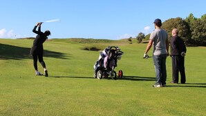 A golf course with a person preparing to hit a golf ball, a golf bag, and two other individuals standing nearby. - Cozy 2-BR House with Terrace, Near Forest and Beaches, Sleeps 6 (Saint-Jean-de-Monts)
