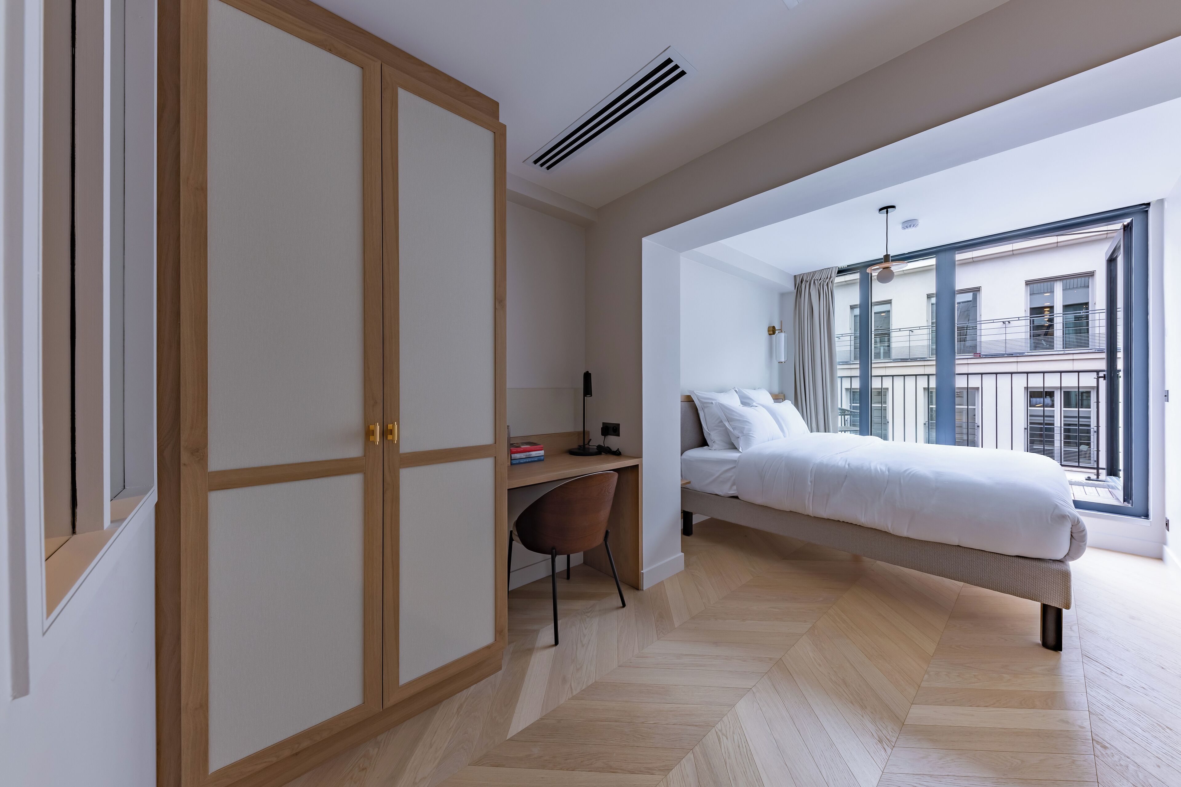 Quarto moderno com cama, escrivaninha e guarda-roupa.