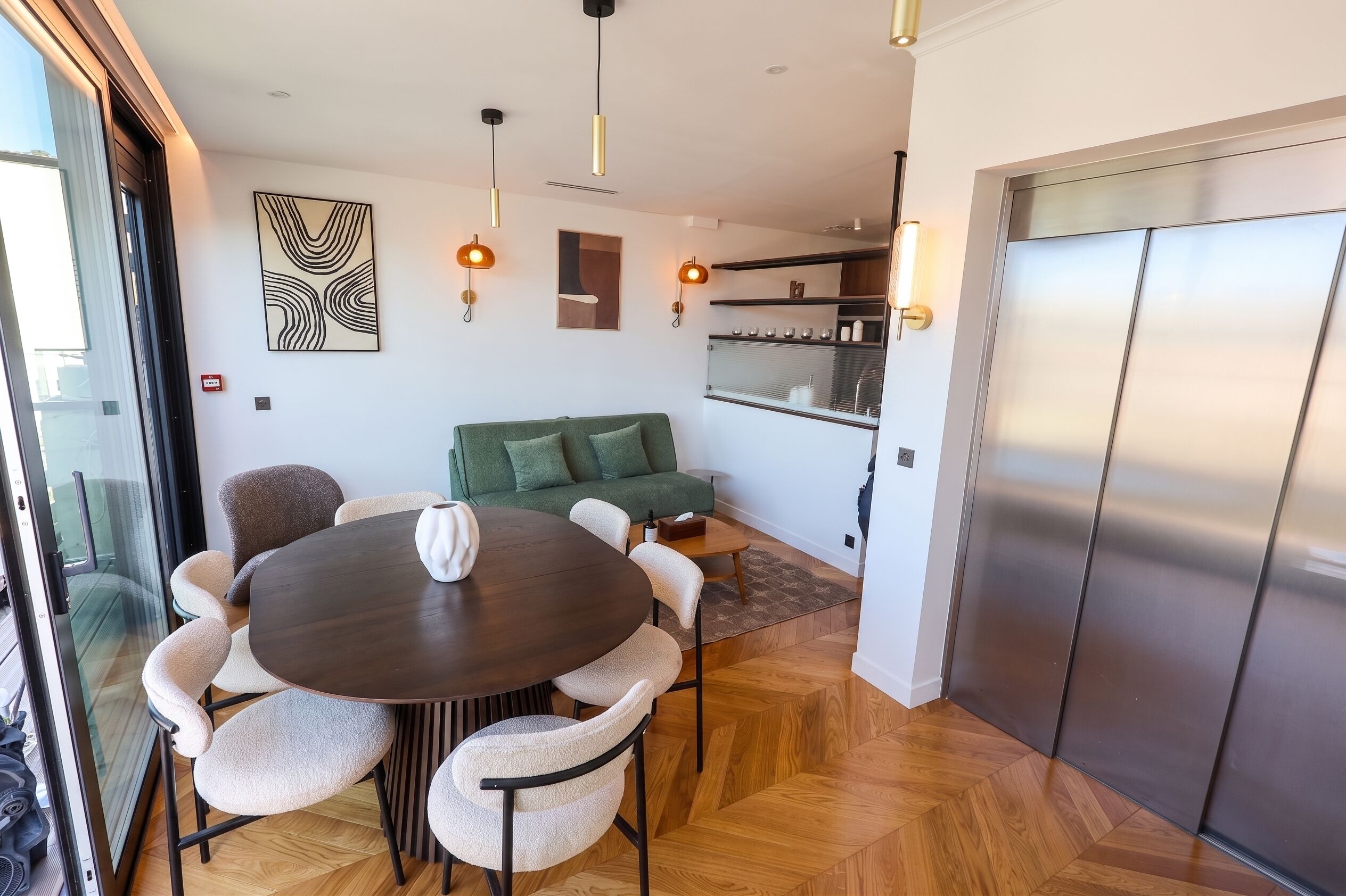 A modern interior with a dining area, a sofa, and a kitchen.