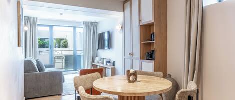 Ein modernes Wohnzimmer mit einem runden Tisch, Sofas und einem großen Fenster.