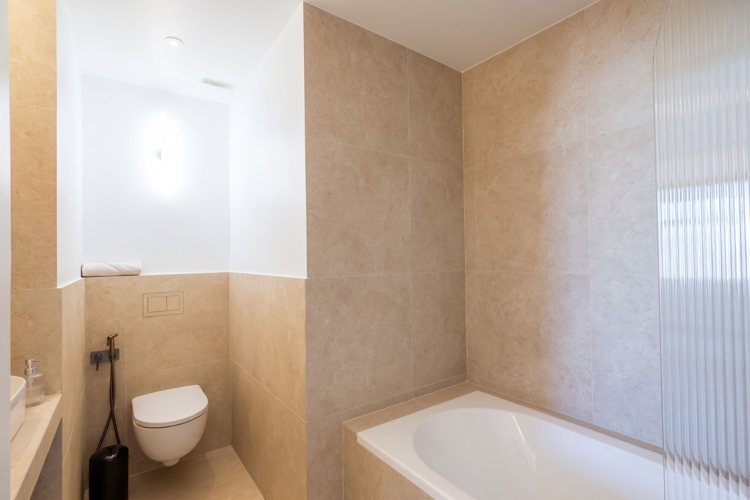 Ein modernes Badezimmer mit Toilette, Dusche und Badewanne.